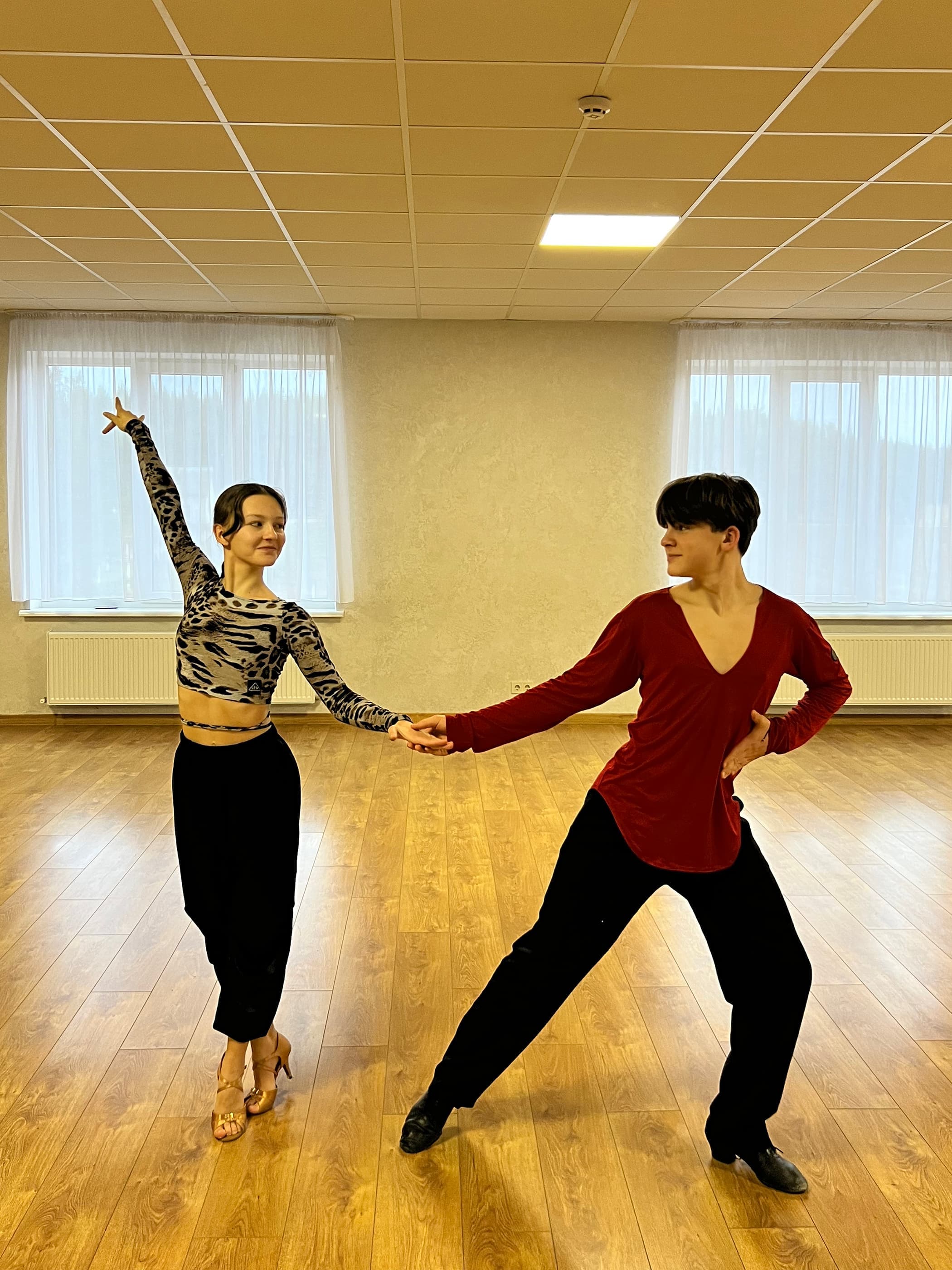 Пара Kvartal Dance тренується у залі, тримаючись за руки
